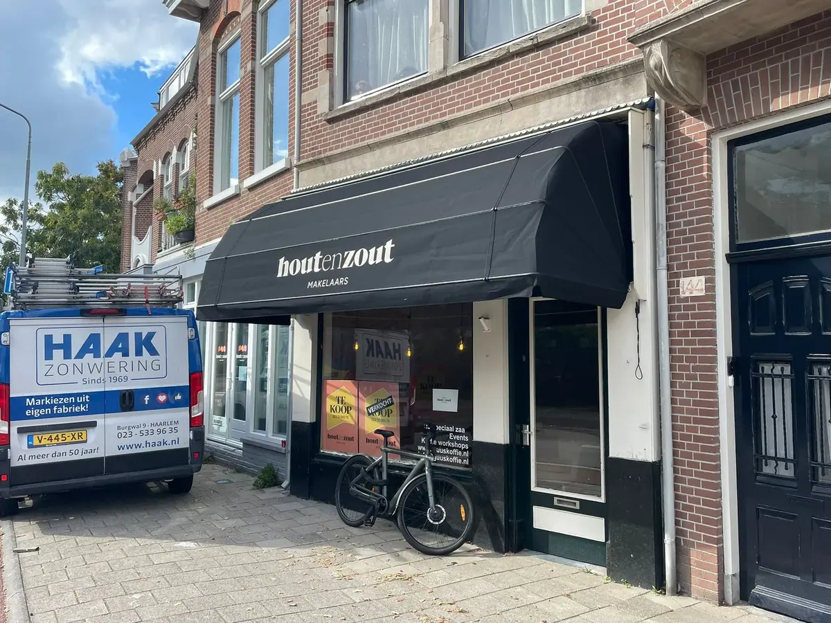 Zwarte markies met logo boven Hout en Zout Makelaars aan de Wagenweg in Haarlem