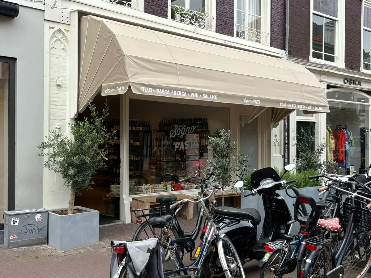 Zandkleurige markies met logo boven Italiaanse speciaalzaak Sogno di Pasta in de Zijlstraat, Haarlem